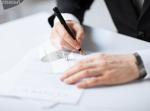 Image of man hands with gambling dices signing contract