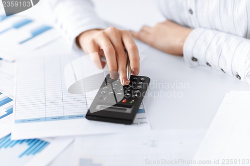 Image of woman hand with calculator and papers