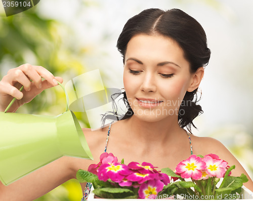 Image of housewife with flower in pot and watering can