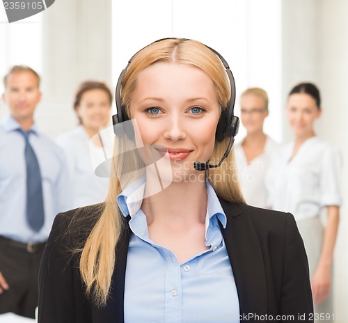 Image of helpline operator with headphones in call centre