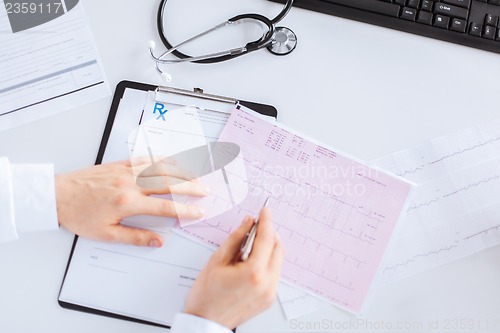 Image of male doctor hands with cardiogram