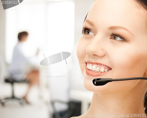 Image of helpline operator with headphones in call centre