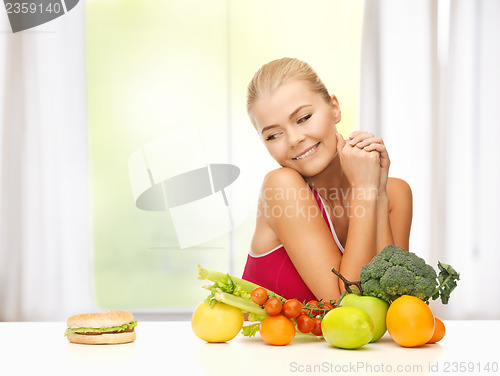 Image of doubting woman with fruits and hamburger