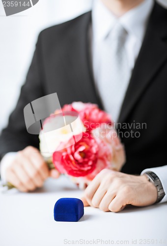 Image of man with gift box in suit