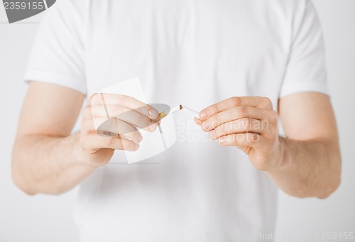 Image of man breaking the cigarette with hands