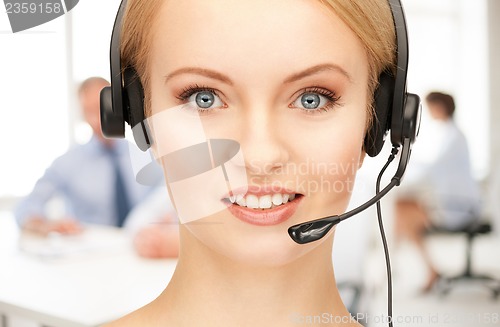 Image of helpline operator with headphones in call centre