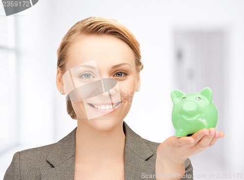 Image of lovely woman with small piggy bank