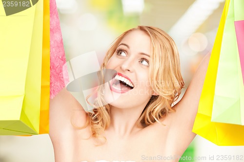 Image of woman holding color shopping bags in mall