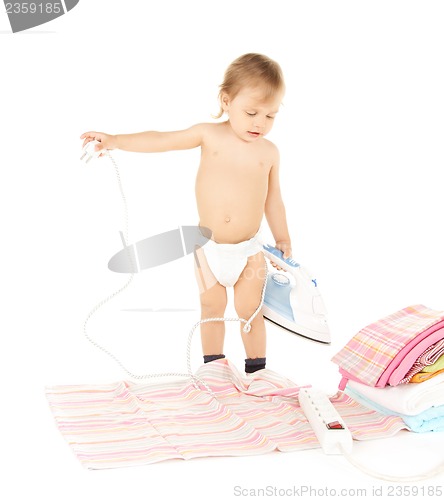Image of baby plugging in iron