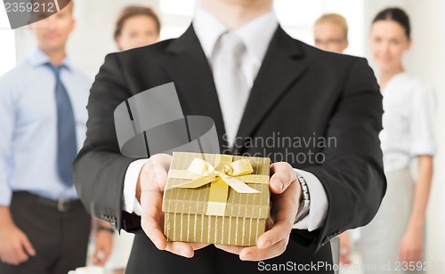 Image of man hands holding gift box in office