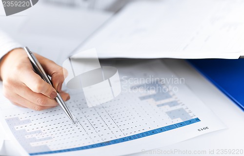 Image of woman hand wrtiting on paper with numbers