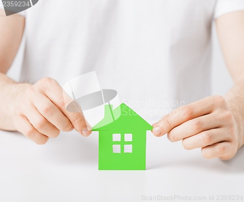 Image of hands holding green house