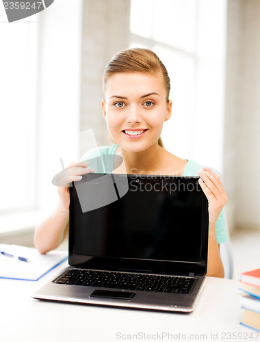Image of smiling student girl with laptop at school