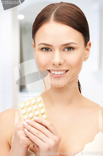 Image of young beautiful woman with pills