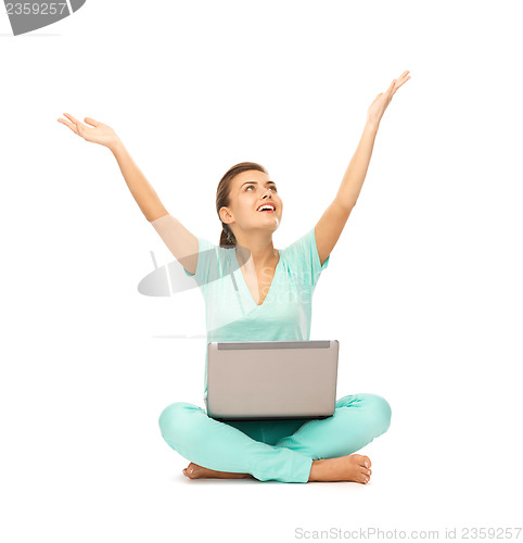 Image of happy girl sitting on the floor with laptop