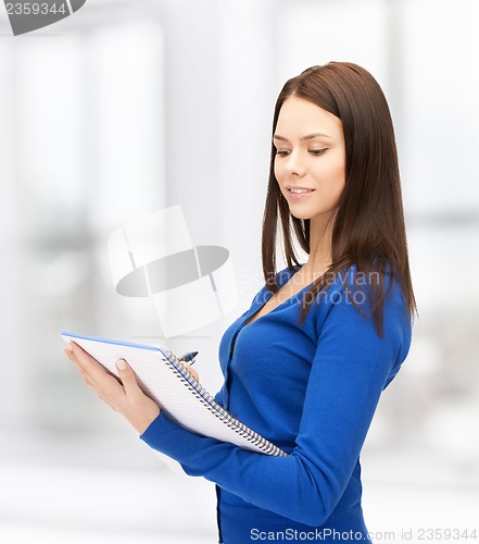Image of smiling young businesswoman with notebook