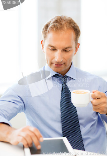 Image of businessman with tablet pc and coffee in office