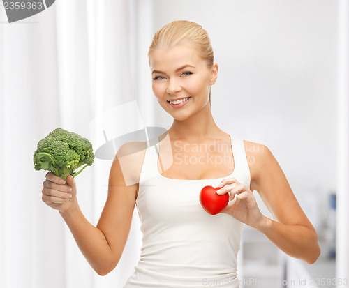 Image of woman holding heart symbol and broccoli