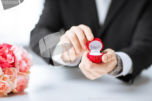 Image of man with gift box and wedding ring