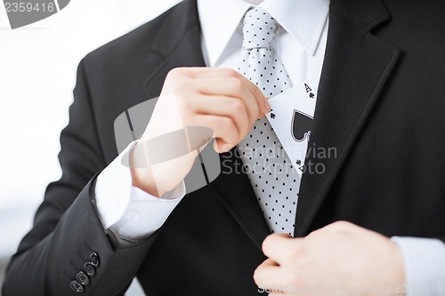 Image of mans hand hiding ace in the jacket pocket