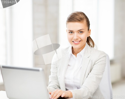 Image of businesswoman with laptop in office