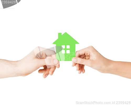 Image of couple hands holding green house