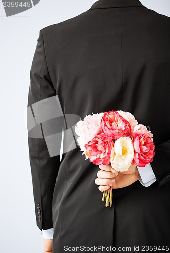 Image of man hiding bouquet of flowers