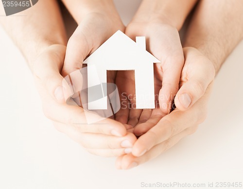 Image of woman and hands with paper house