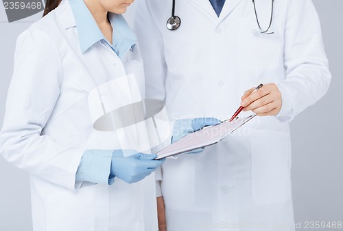 Image of nurse and male doctor holding cardiogram