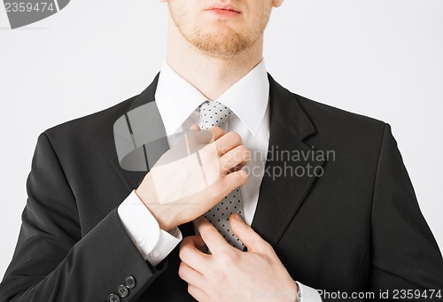 Image of man adjusting his tie
