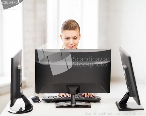 Image of businesswoman with computer and monitors in office