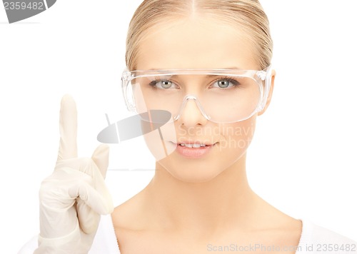 Image of scientist in eyeglasses holding finger up