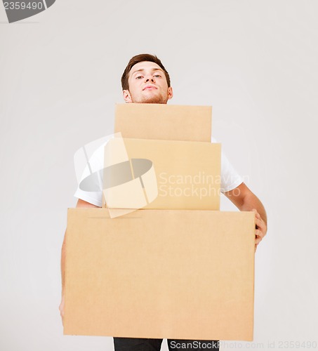 Image of young man carrying carton boxes