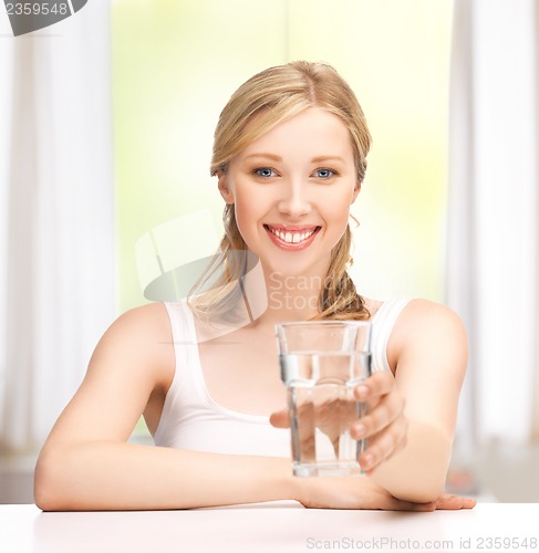 Image of young smiling woman with glass of water