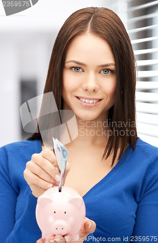 Image of lovely woman with piggy bank and money