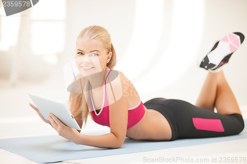 Image of woman lying on the floor with tablet pc