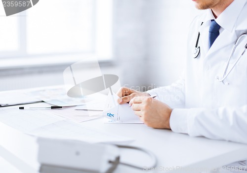 Image of male doctor writing prescription paper