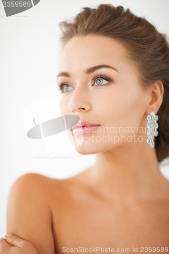 Image of woman wearing shiny diamond earrings