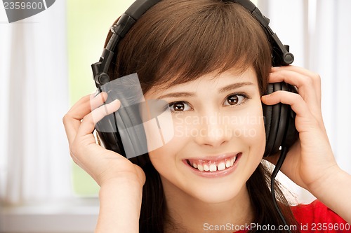 Image of happy teenage girl in big headphones