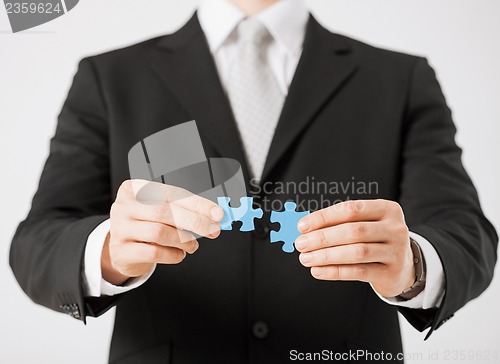 Image of man trying to connect puzzle pieces