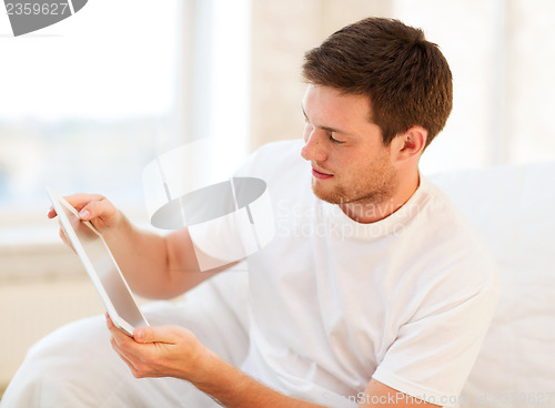 Image of man playing with tablet pc at home