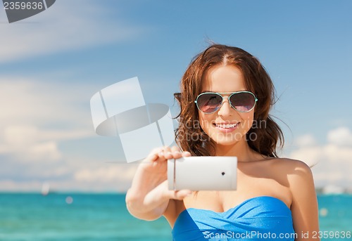 Image of woman in bikini with phone