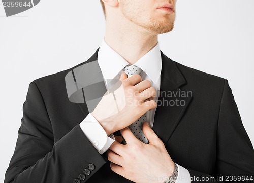 Image of man adjusting his tie