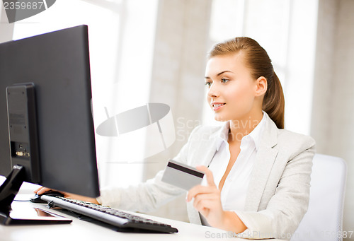 Image of businesswoman with laptop using credit card