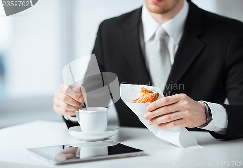Image of man with tablet pc and cup of coffee