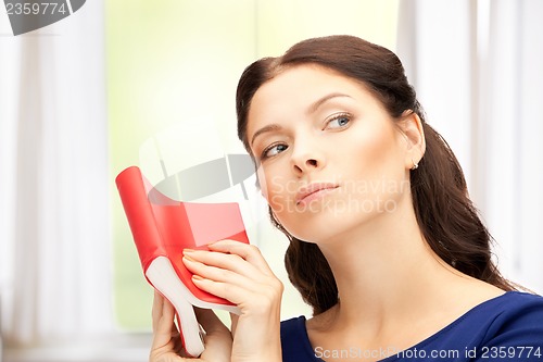 Image of calm and serious woman with book