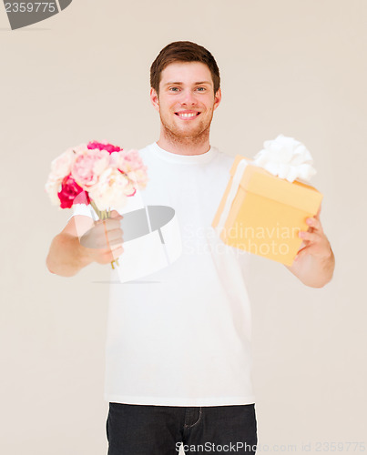 Image of man holding bouquet of flowers and gift box