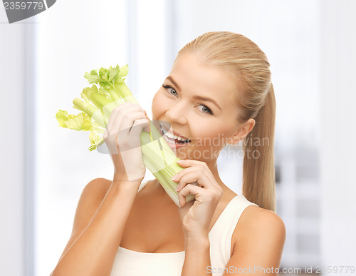 Image of woman biting piece of celery or green salad