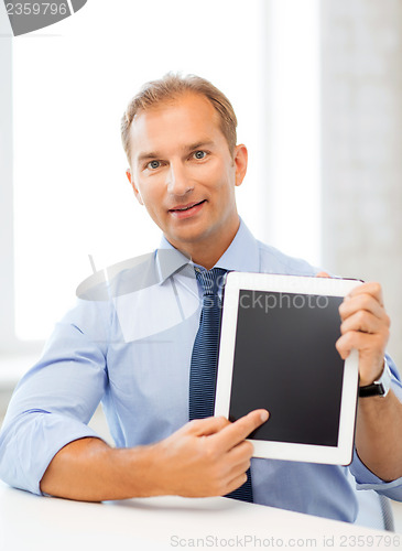 Image of smiling businessman with tablet pc in office