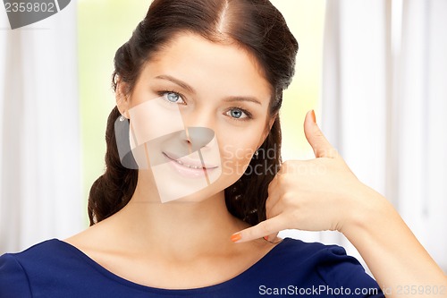 Image of woman making a call me gesture